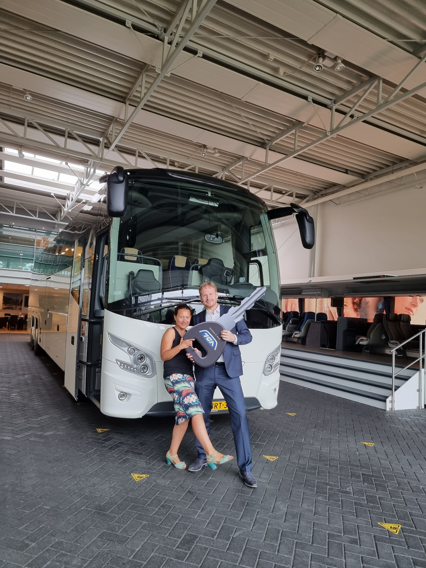 Eigenaren van Camaleon Tours met de sleutel van een nieuwe VDL touringcar
